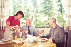 A smiling Nurse Next Door Caregiver with client and family. 